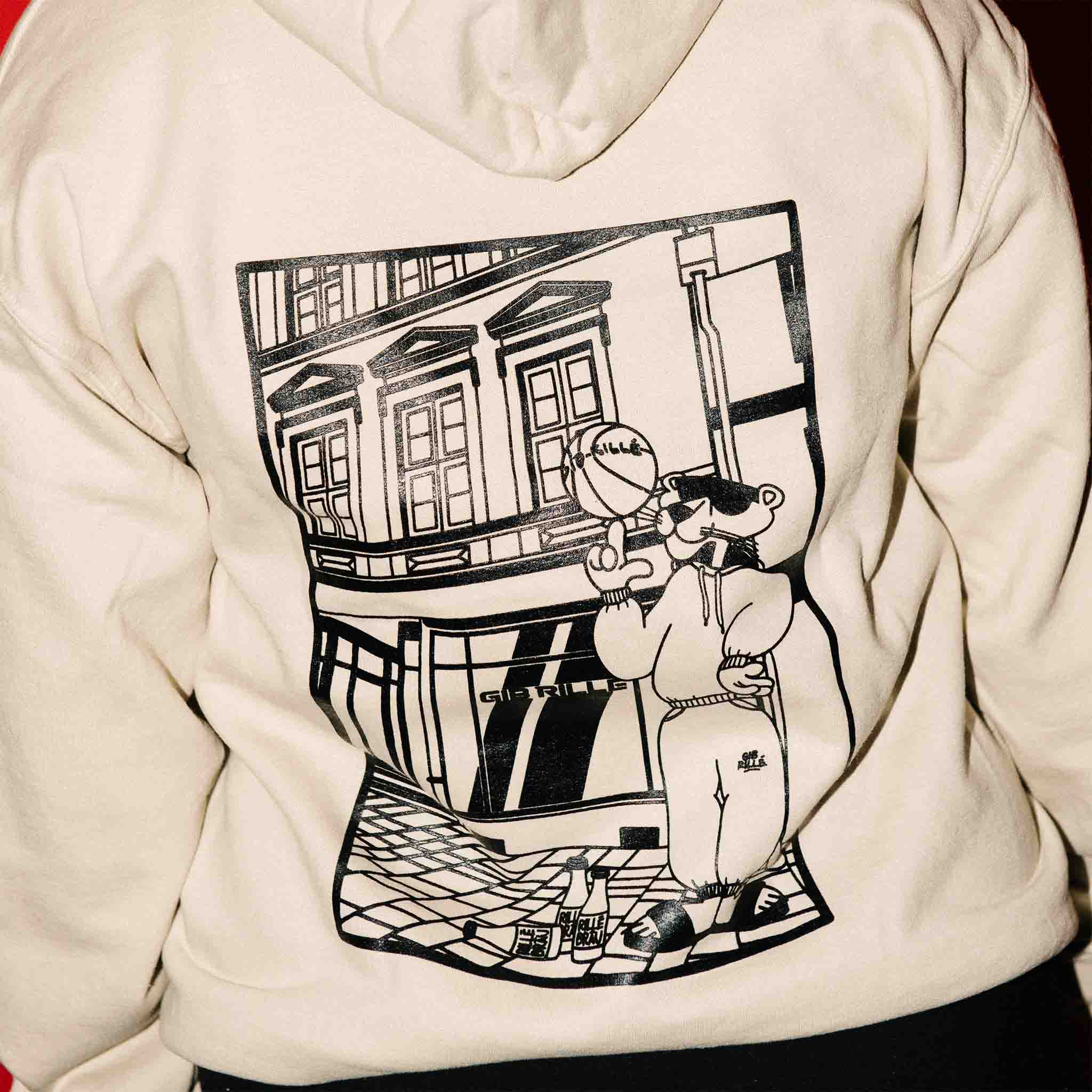 Close-up des Backprints des Gib Rillé Panther-Hoodies, auf dem ein Panther im Comic-Stil vor einem Pop-up-Store steht. Der detaillierte Print zeigt den Panther als stilisierte, auffällige Grafik.